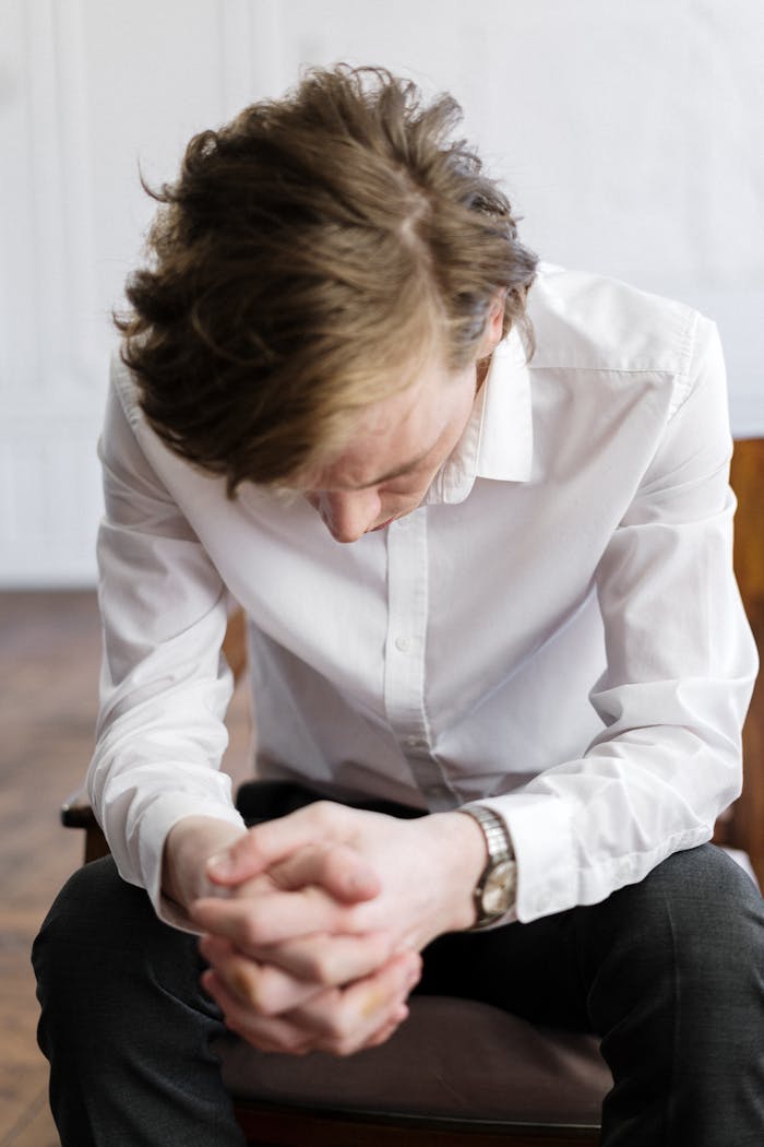 A man indoors deep in thought, captured in a peaceful setting.